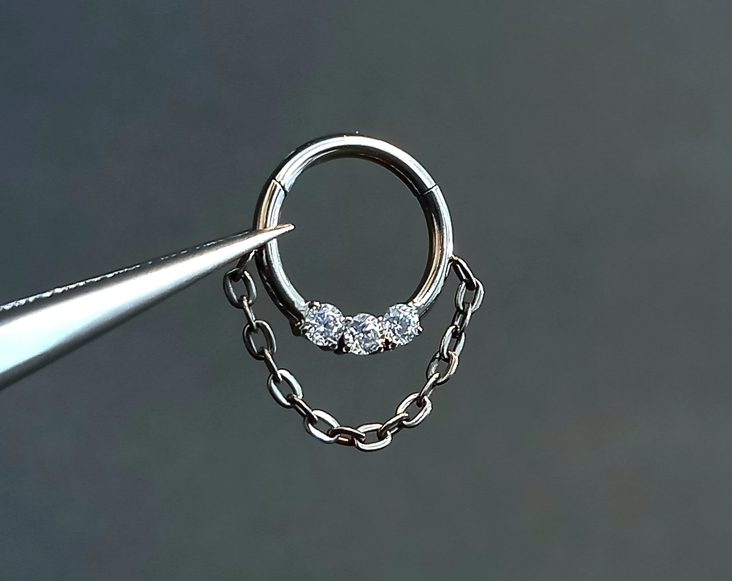Titanio grado implante. Clicker con tres brillos clear y cadena