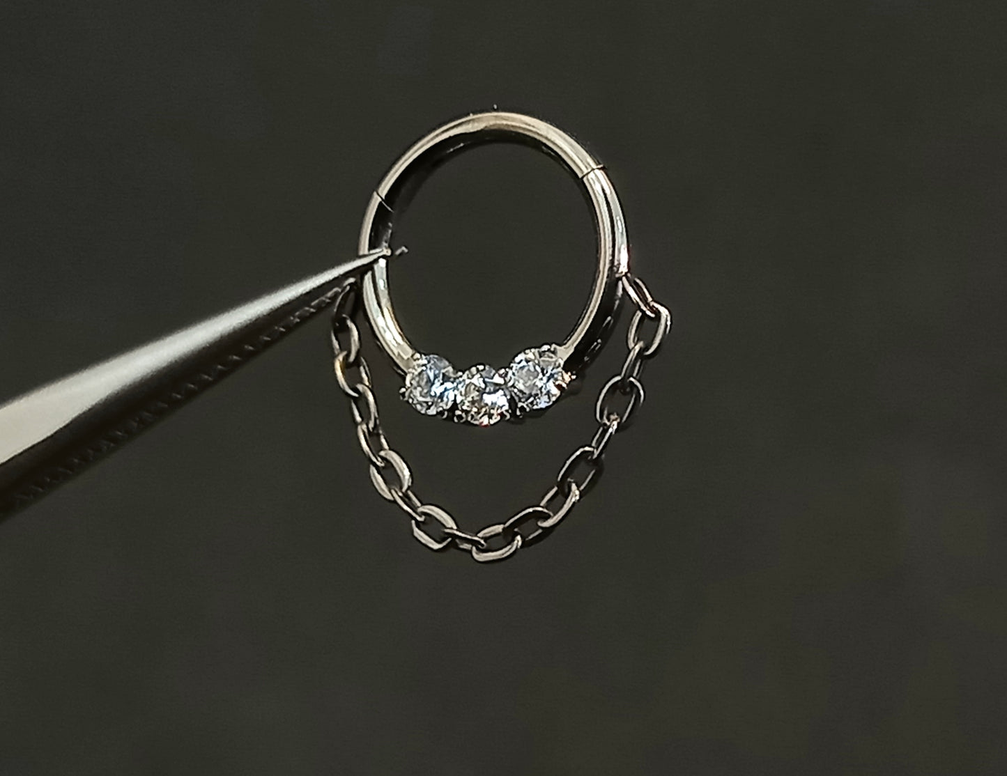 Titanio grado implante. Clicker con tres brillos clear y cadena