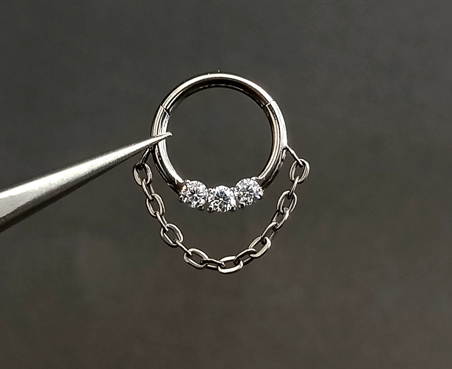 Titanio grado implante. Clicker con tres brillos clear y cadena