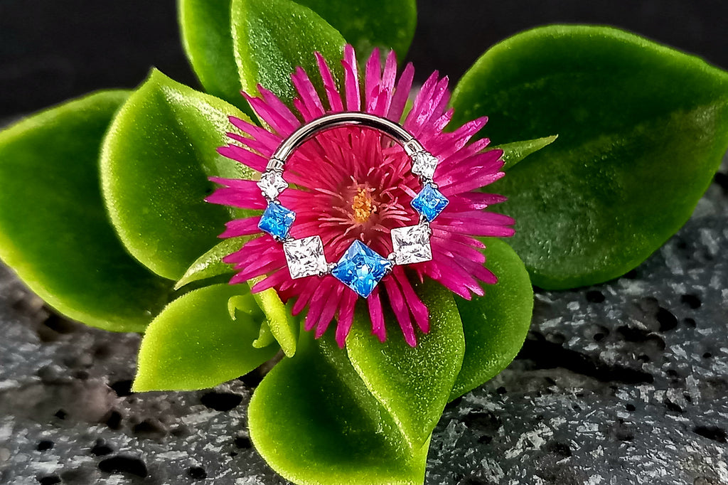 Argolla clicker zircón con rombos azul y clear