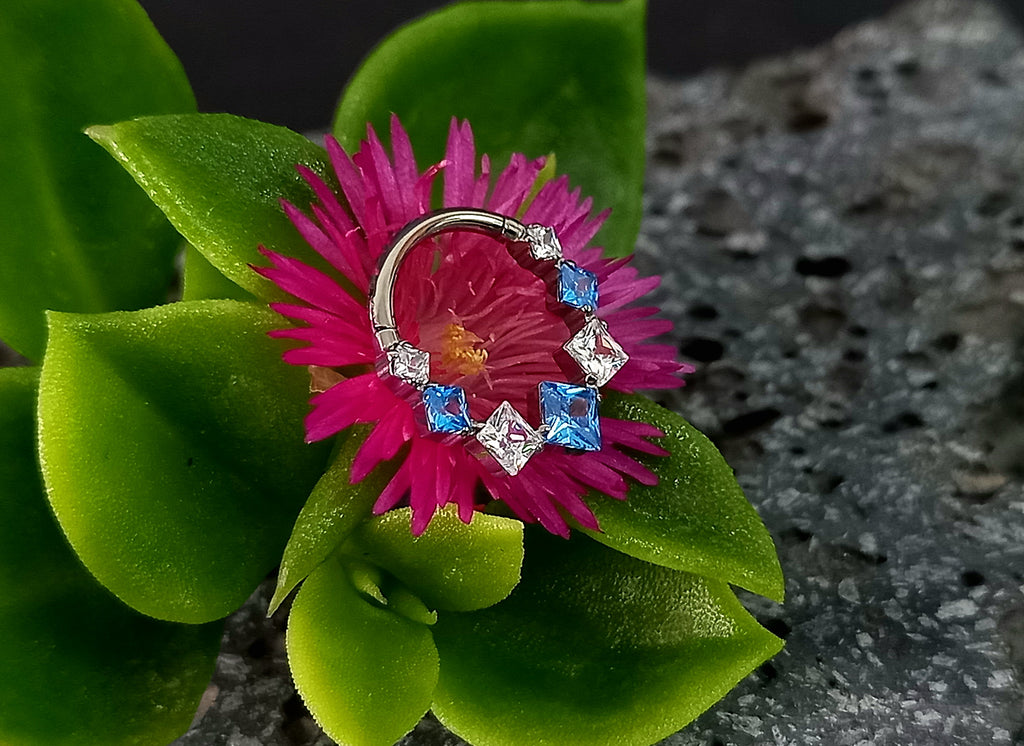 Argolla clicker zircón con rombos azul y clear